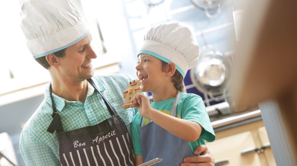 Quality time man and son with chef hats cooking together